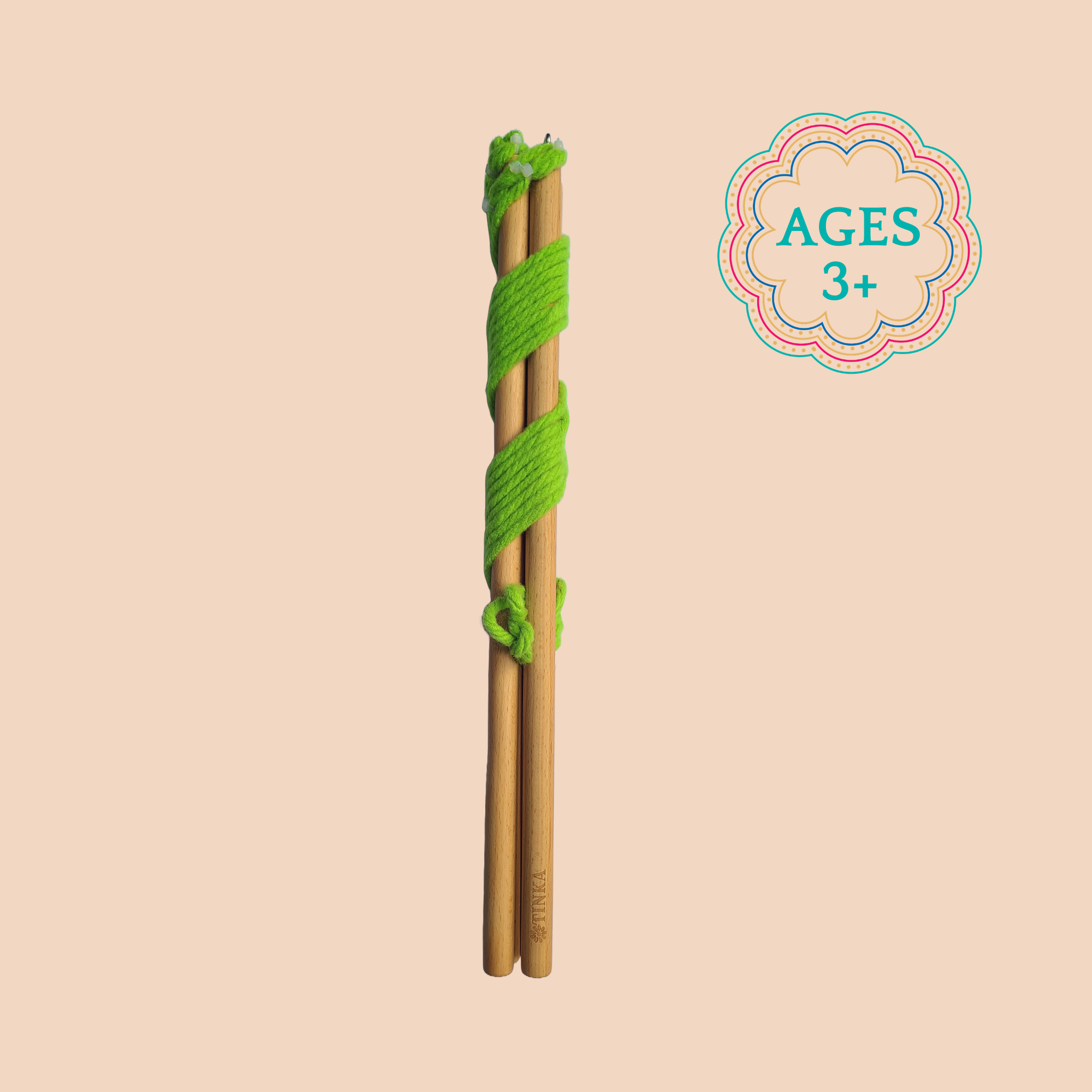 A wooden wand wrapped in green yarn made for ages 6+