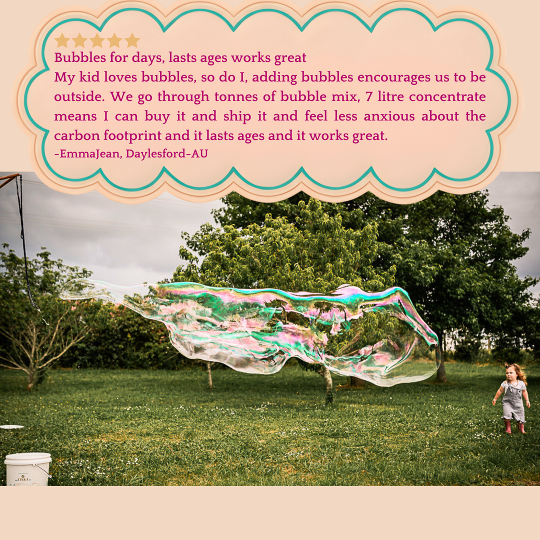 Child playing with large bubbles in a grassy field with a review text overlay.