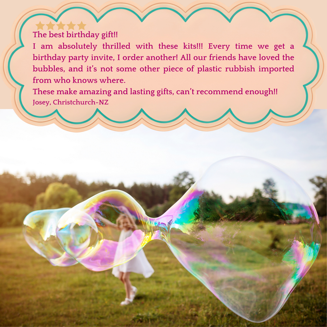 A little girl with a large colourful bubble floating in a grassy outdoor field and a customer review text box at the top with a peach scalloped border.